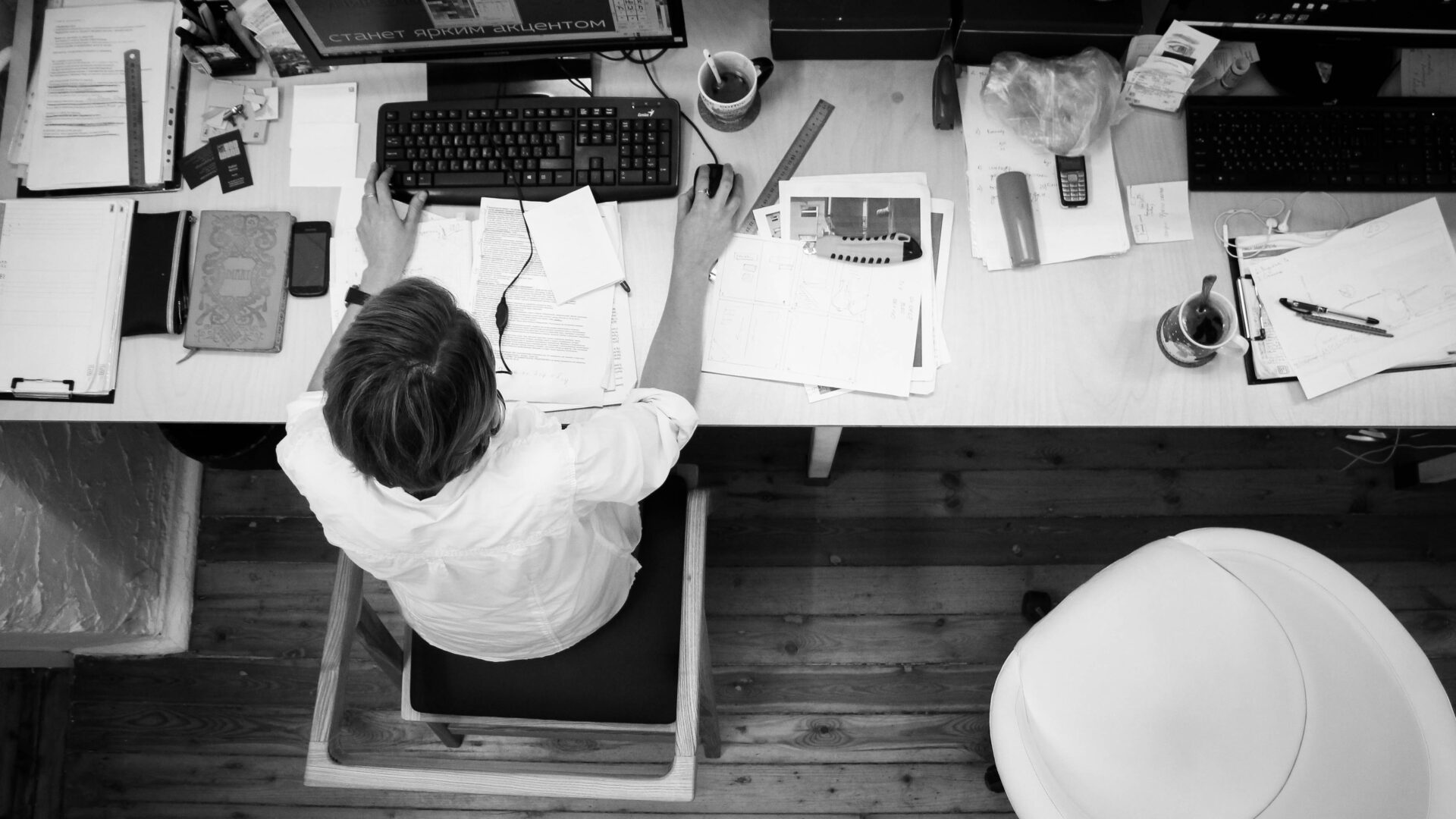 homme assis à son bureau rempli de papier